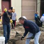 Volunteers clean the driveway of an apartment building